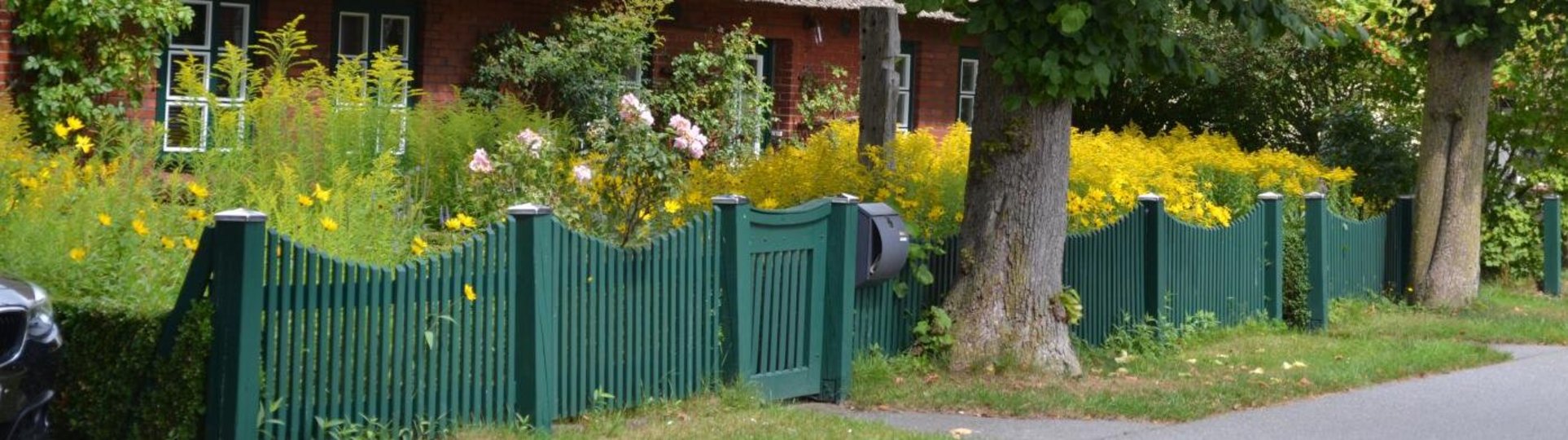 Haus mit einem grünen Zaun