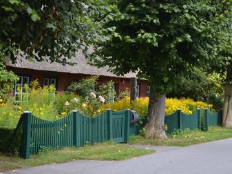 Haus mit einem grünen Zaun