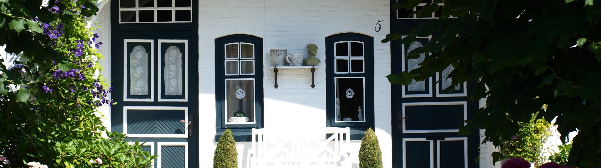 grün-weiße Türen an weißem Eingangsbereich eines Hauses