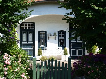 grün-weiße Türen an weißem Eingangsbereich eines Hauses