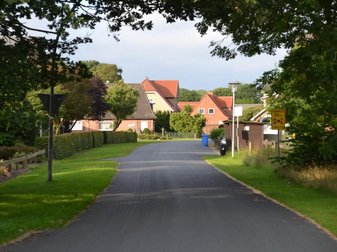Straße mit Schild zur Geschwindigkeitsbegrezung aufgrund von Schulkindern