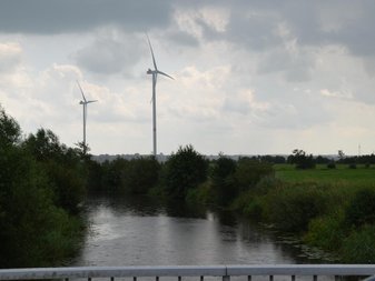 zwei Windräder hinter einem Fluss